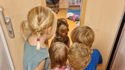 Ein beliebter Mitarbeiter: Bürohund Carlo mit den Kindern.