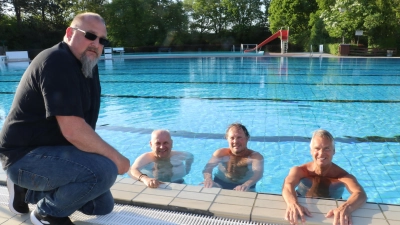 Am und im Becken (v.li.): Der stellvertretende Betriebsleiter der Bäderbetriebe, geprüfter Schwimmmeister Wolfgang Zerban ist beim Anschwimmen von Thomas Silbermann, Cornelius Nolte und Axel Brockmann dabei. (Foto: gi)