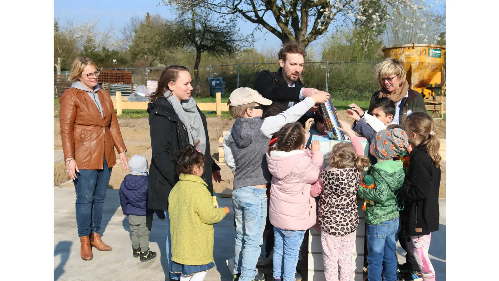 Der Kaufmännische Leiter der PLSW, Frederik Hansel bringt während der Grundsteinlegung für die Kita „Mittendrin“ die Zeitkapsel gemeinsam mit Kindergartenkindern an ihren Platz.  (Foto: Borchers, Bastian)