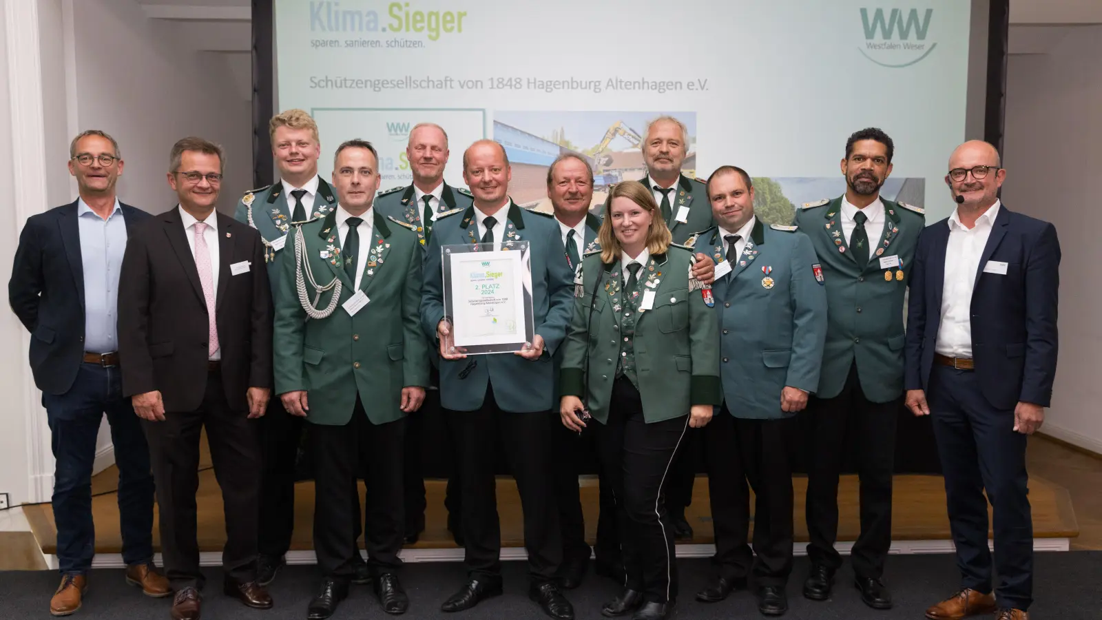 Jury-Mitglieder Heinz-Jörg Heinemann (li.) und Andreas Speith (re.) gratulieren zusammen mit dem Bürgermeister der Samtgemeinde Sachsenhagen Jörn Wedemeier (2.v.li.) der Schützengesellschaft.  (Foto: Christian Schwier)