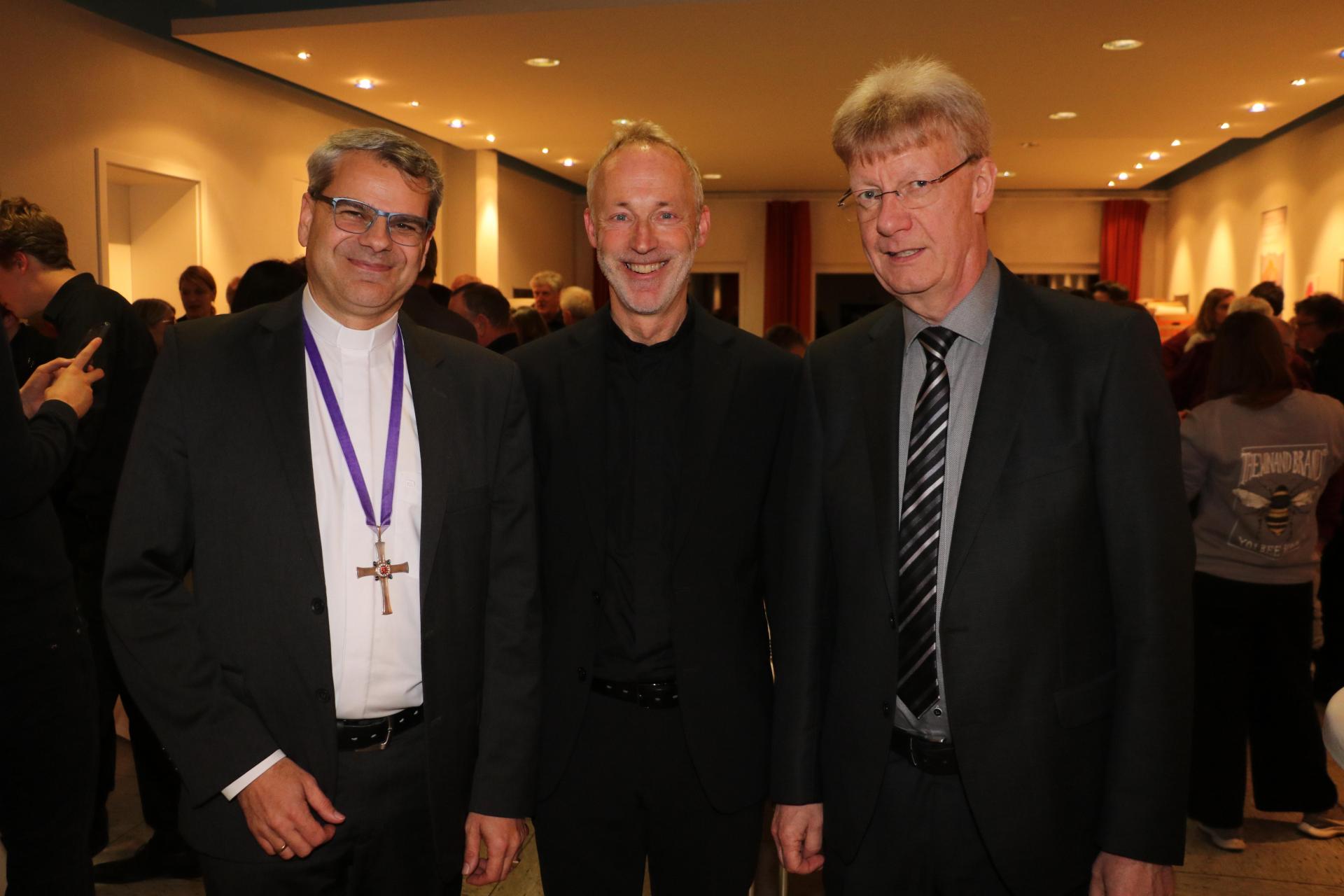 Haben das Konzert verfolgt (v.li.): Landesbischof Oliver Schuegraf, Pastor Cord Wilkening und Chorleiter Andreas Meyer. (Foto: gi)