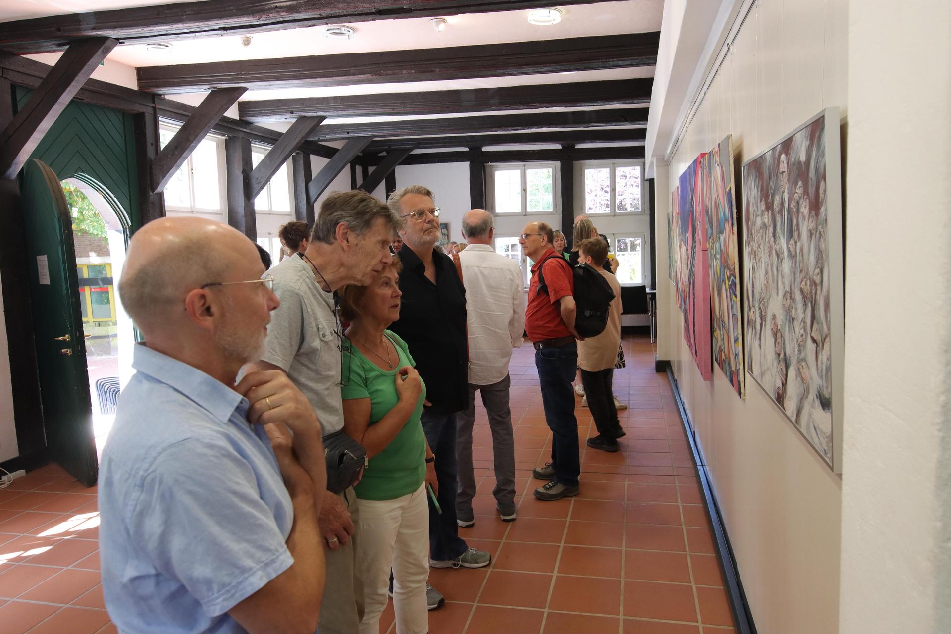 Betrachten die Bilder: Besucher der Ausstellung. (Foto: tau)