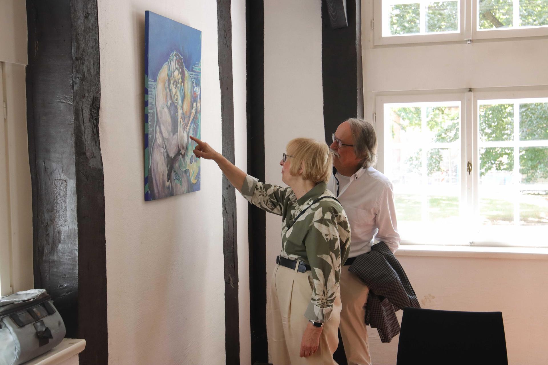Betrachten die Bilder: Besucher der Ausstellung. (Foto: tau)