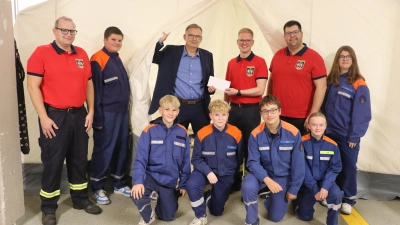Bei der Scheckübergabe (v.li.): Henrik Raatz, Torsten Schmidt, Leon Klemm und Ortsbrandmeister Marcel Nellesen freuen sich mit Mitgliedern der Jugendfeuerwehr über die Volksbankspende.  (Foto: gi)