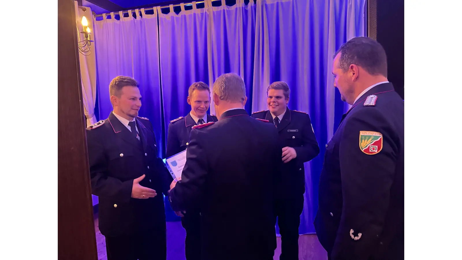 Stadtbrandmeister Martin Ohlendorf spricht Beförderungen aus für (v.li.): Marcel Siekmann, Tim Rudnick und Jeremy Fienemann. Einer der ersten Gratulanten ist Robert Focke.  (Foto: gi/Feuerwehr)