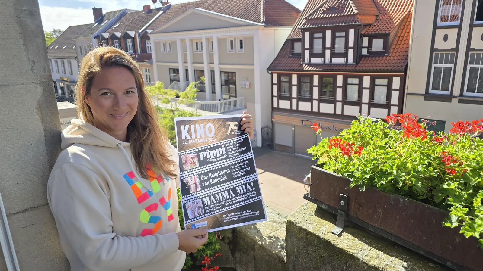 Mit Kinoplakat: Janna Grunewald vom Fachdienst Kultur. Im Hintergrund das Stadttheater. (Foto: tau)