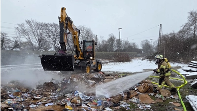 Unterstützt die Löscharbeiten: Ein Bagger des Bauhofes verteilt das gepresste Altpapier. (Foto: Feuerwehr)