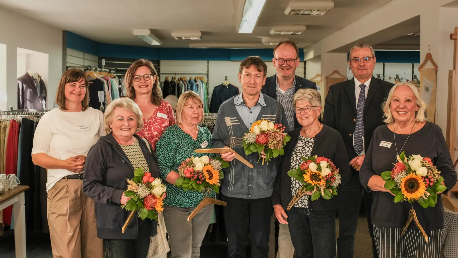 Mit Blumen und goldenen Kleiderbügeln: Das Team des Kleiderladens. (Foto: Mirko Bartels)