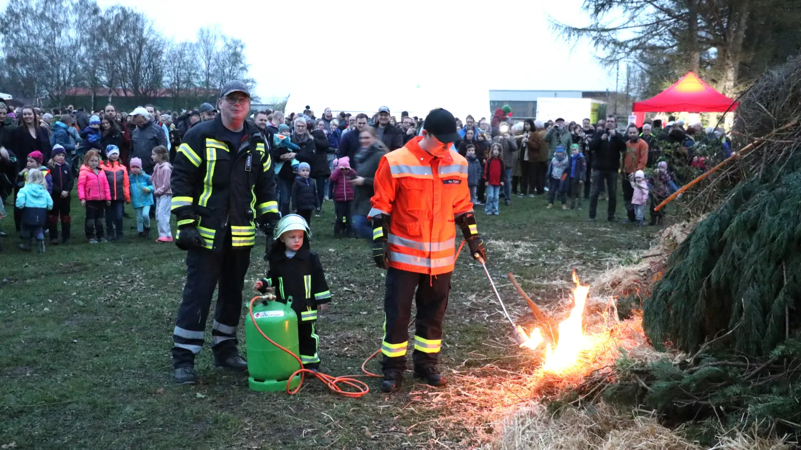 Tobias Bender und Henning Pickert (v.li.) zünden mit Lasse Battermann den Holzhaufen an.  (Foto: gi)
