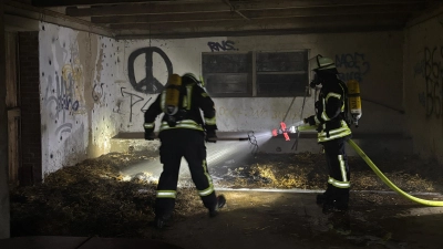 Löschen in einer Scheune Glutnester ab: Einsatzkräfte der Feuerwehr. (Foto: Feuerwehr)