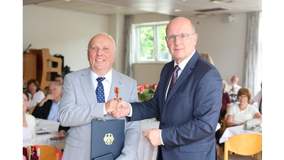 Wilfried Wlotzka nimmt das Bundesverdienstkreuz von Landrat Jörg Farr entgegen.  (Foto: bb)