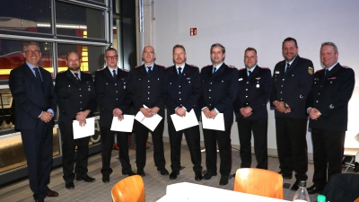 Mit Urkunden (v.li.): Carsten Piellusch, Tim Wellmann, Björn Trittel, Florian Arndt, André Laqua,, Kai Gages sowie die stellvertretenden Stadtbrandmeister Benjamin Heidorn und Robert Focke und Stadtbrandmeister Martin Ohlendorf. (Foto: gi)