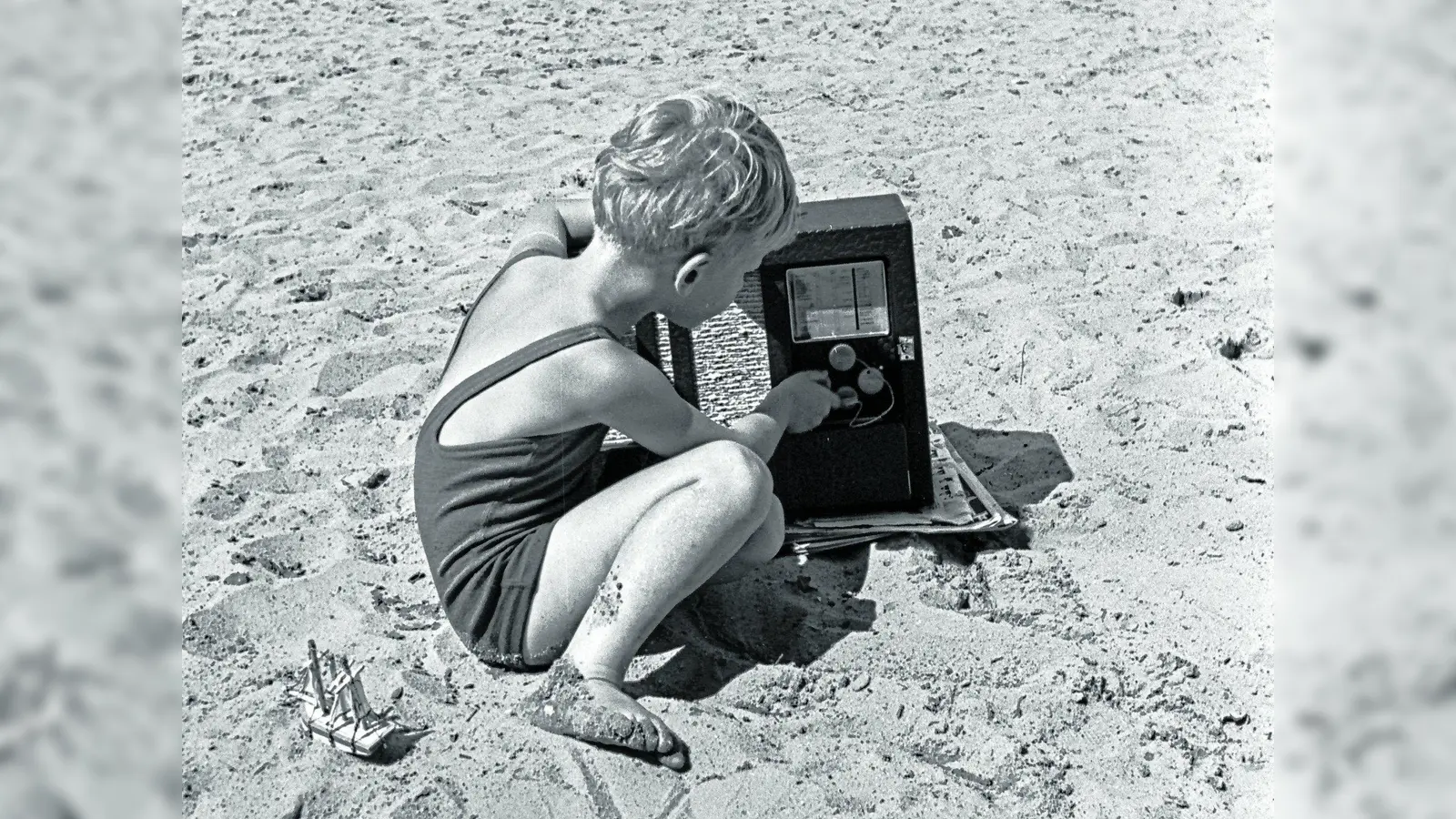 JWCKH0 Little boy changing channel on radio on beach.. Image shot 1930. Exact date unknown. (Foto: mk)