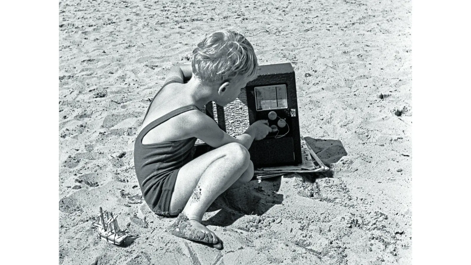 JWCKH0 Little boy changing channel on radio on beach.. Image shot 1930. Exact date unknown. (Foto: mk)