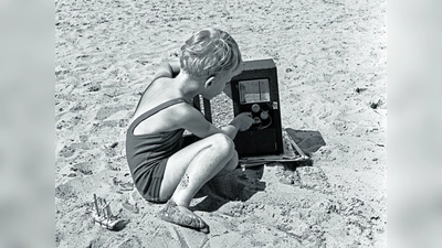 JWCKH0 Little boy changing channel on radio on beach.. Image shot 1930. Exact date unknown. (Foto: mk)