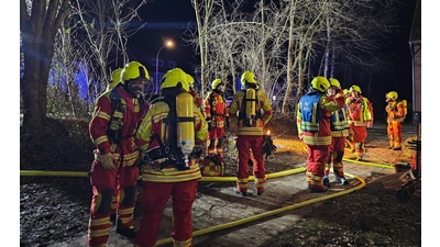 Zahlreiche Atemschutztrupps unter schwerem Atemschutz stehen vor dem Gebäude bereit. (Foto: privat)