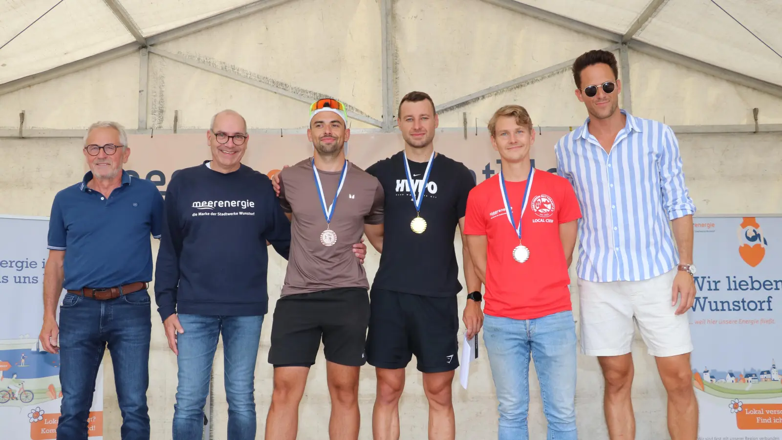 Siegerehrung Volkstriathlon (v.li.): Abteilungsleiter Wolfgang Scharf, Henning Radant von den Stadtwerken, die Platzierten Konstantin Theile, Malte Wortmann und Frithjof Kögler sowie Moderator Henrik Scharf. (Foto: gi)