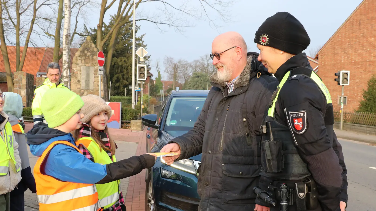 Kinder der 4a aus der Grundschule verteilen an einen Autofahrer (er war nicht zu schnell) zur Kenntnis eine Gelbe Karte.  (Foto: gi)