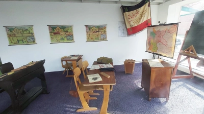 Blick ins aktuelle „Suthfelder Geschichtsfenster”, mit einem Rohrstock auf dem Lehrerpult und der Ausstattung eines historischen Klassenzimmers. (Foto: gk)