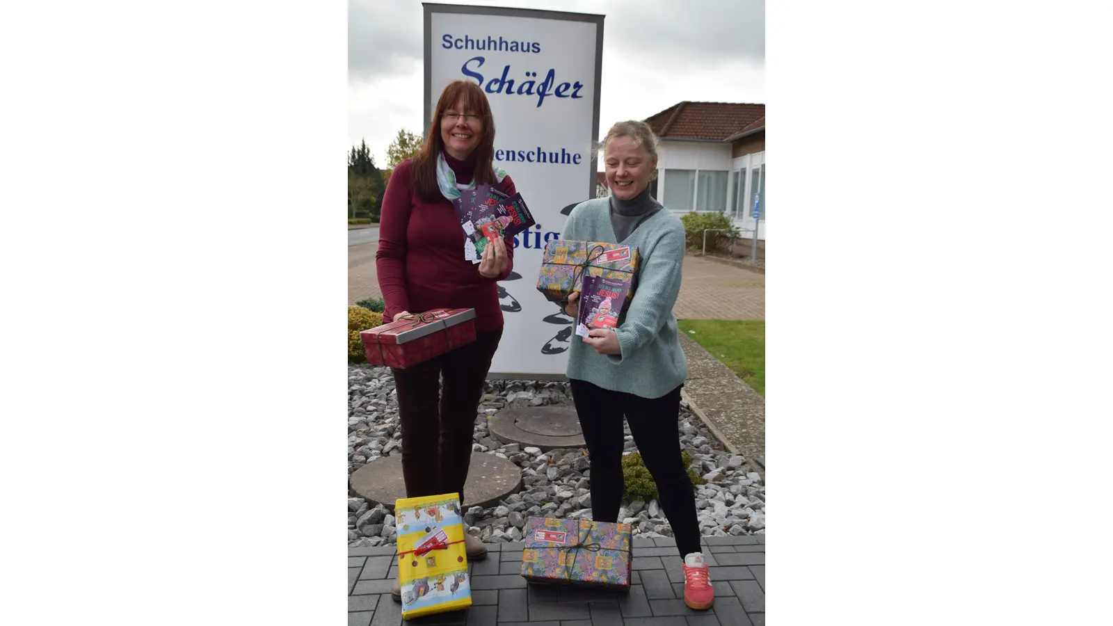 Corinna Brockhaus (Sammelpunktleiterin, li.) und Jessica Schäfer vom gleichnamigen Schuhhaus präsentieren liebevoll gepackte Geschenkkartons. (Foto: ab)
