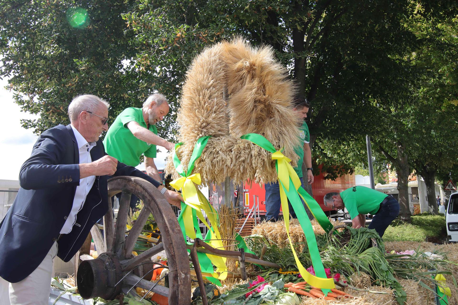 Die Erntekrone bekommt einen Ehrenplatz: Der Vorsitzende des KCL, Karsten Kutz (li.), richtet die Schleifen aus. (Foto: tau)