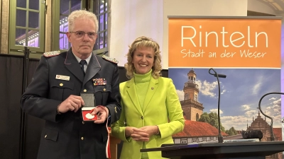 Bürgermeisterin Andrea Lange zeichnet Kreisbrandmeister Klaus-Peter Grote mit dem Rintelner „Messetaler” aus. (Foto: ste)