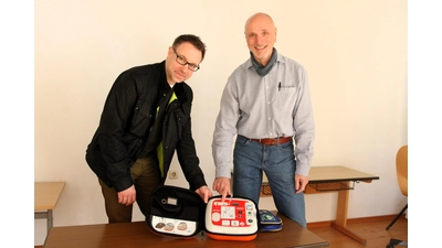 Björn Gereke (li.), Vorsitzender des Schulfördervereins, und Direktor Torsten Rolke bei der Übergabe des Defibrillators. (Foto: Borchers, Bastian)