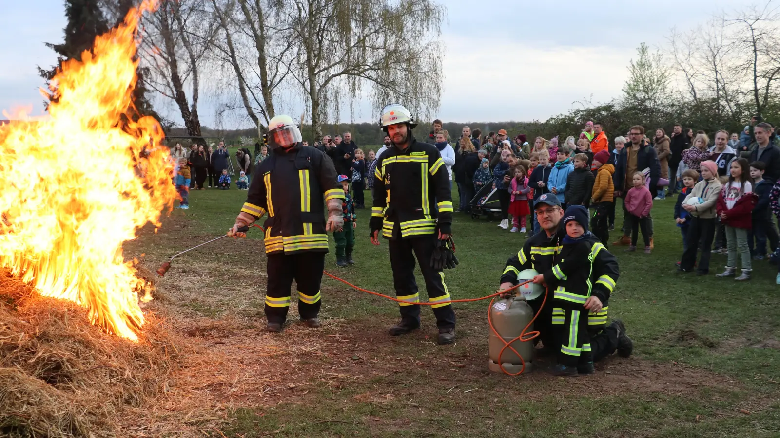 Entzünden das Osterfeuer (v.li.): Ortsbrandmeister Thomas Sadocco, stellvertretender Ortsbrandmeister Ruven Rintelmann, der fünf Jahre alte Lasse und der künftige Ortsbrandmeister Florian Kauke. (Foto: gi)